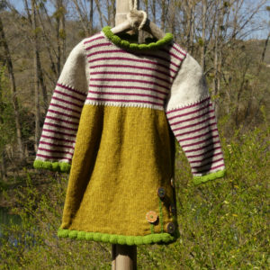 Robe en laine couleur ocre avec des bordures couleurs vertes et le haut est rayé couleur framboise sur un fond écru